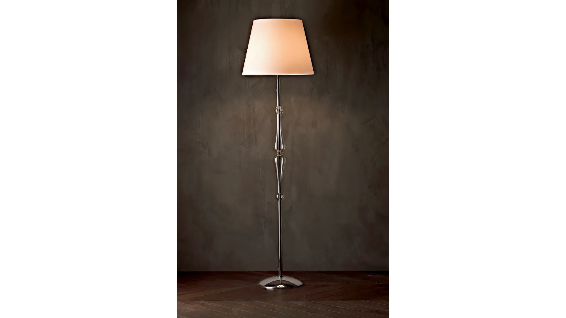 Lampada da terra Miss con struttura cromata,  stelo sagomato in pirex trasparente e paralume in tessuto di Le Fablier